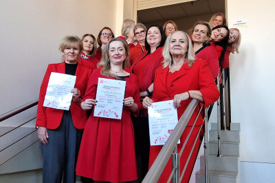 Dyrekcja i pracownicy ubrani na czerwono na schodach.